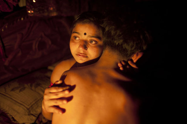 ATTENTION EDITORS: THIS PICTURE IS 1 OF 25 TO ACCOMPANY PICTURE PACKAGE 'BANGLADESH - TEENAGE PROSTITUTES'. SEARCH FOR KEYWORD "BROTHEL" TO SEE ALL IMAGES PXP101-125. Seventeen-year-old prostitute Hashi, embraces a Babu, her "husband", inside her small room at Kandapara brothel in Tangail, a northeastern city of Bangladesh, March 4, 2012. Many young and inexperienced prostitutes have "lovers" or "husbands" who normally live outside the brothel occasionally taking money and sex from them in exchange for security in this male dominated society. She earns about 800-1000 taka daily ($9.75 - $12.19) servicing around 15-20 customers every day. Hashi is one of hundreds of mostly teenage sex workers living in a painful life of exploitation in Kandapara slum's brothel who take Oradexon, a steroid used by farmers to fatten their cattle, in order to gain weight and appear "healthier" and more attractive to clients. Picture taken March 4, 2012. REUTERS/Andrew Biraj (BANGLADESH - Tags: SOCIETY BUSINESS EMPLOYMENT HEALTH DRUGS TPX IMAGES OF THE DAY)