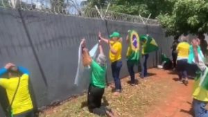 Bolsonaristas ajoelham e oram em frente ao muro do Exército